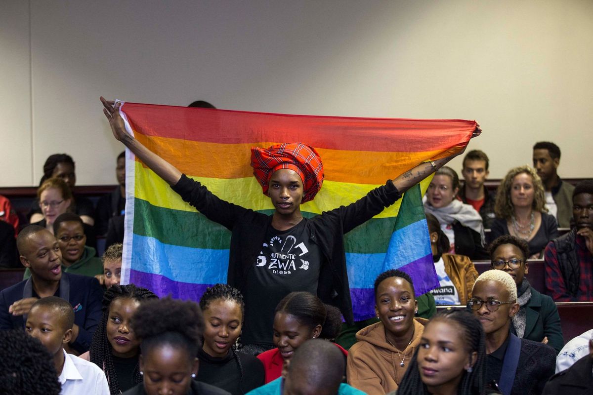 An image of an activist holding up a rainbow flag inside the Botswana High Court. 