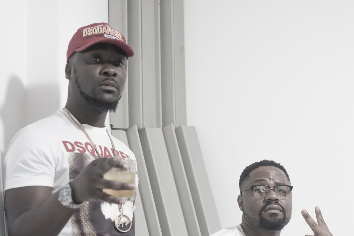 Rhymez (standing) and Phil Chard (sitting) pose for a photo during a studio session.